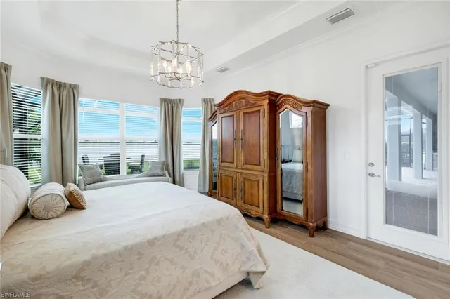 a bedroom with a large bed and a chandelier