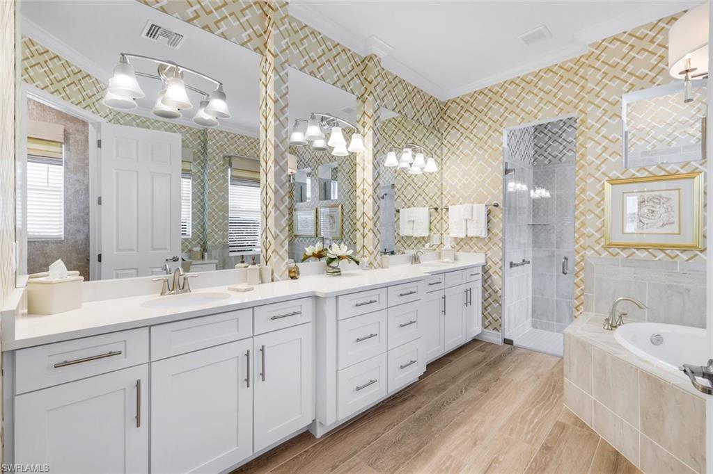 14630 Blue Bay Circle Fort Myers, FL 33913 - Photo 16 of 49 a spacious bathroom with double vanity sinks a large mirror and a bathtub