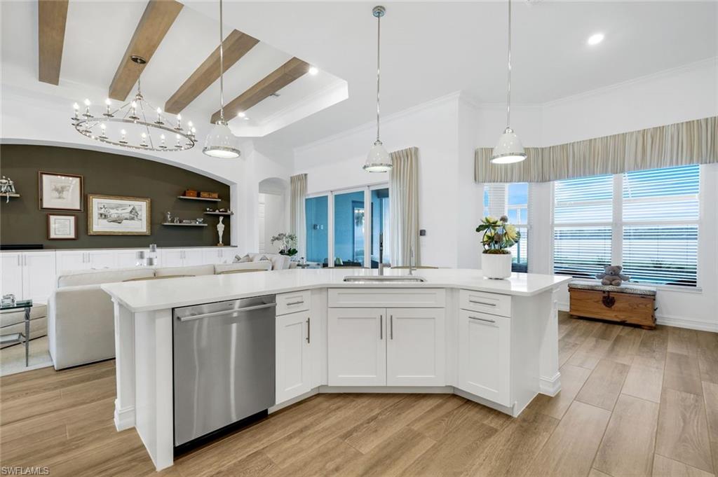 14630 Blue Bay Circle Fort Myers, FL 33913 - Photo 49 of 49 a large white kitchen with a large island oven a sink dishwasher a stove and a dining table with wooden floor