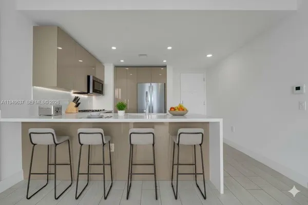 a kitchen with granite countertop white cabinets and chairs