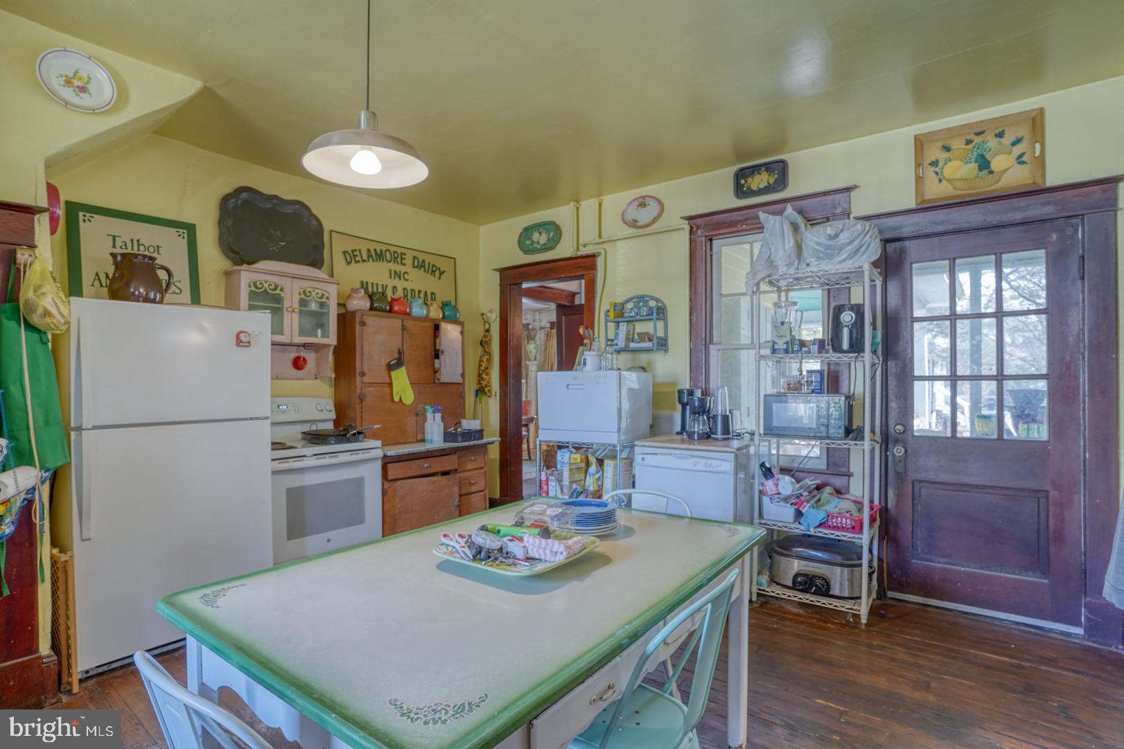 4096 Main Street Trappe, MD 21673 - Photo 34 of 70 a kitchen with stainless steel appliances granite countertop a stove a refrigerator a sink a dining table and chairs with wooden floor