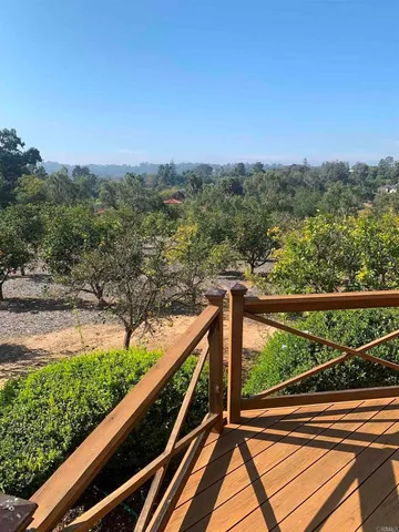 a view of balcony with wooden floor and fence