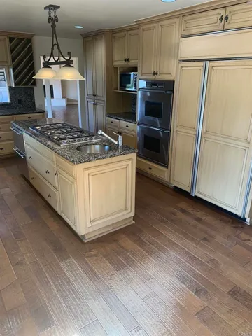 a kitchen with stainless steel appliances granite countertop a refrigerator stove and sink