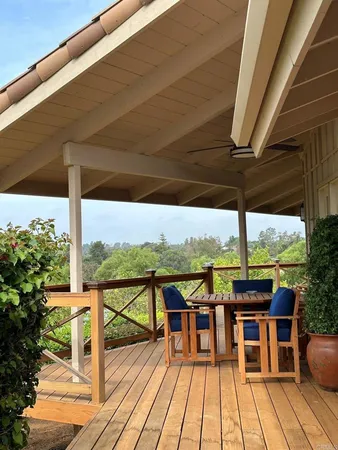 a view of a balcony with chairs and wooden floor