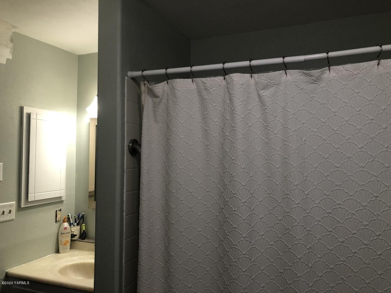 796 East Allen Road Sunnyside, WA 98944 - Photo 13 of 15 a bathroom with a shower curtain and a sink