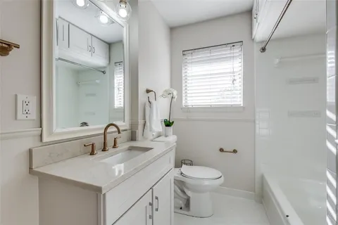 a bathroom with a toilet sink vanity and mirror