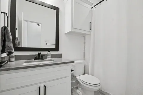 a bathroom with a toilet sink and mirror