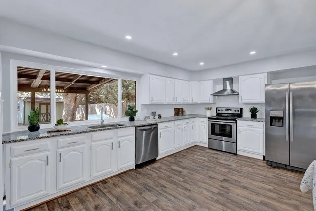 a kitchen with granite countertop white cabinets and white appliances