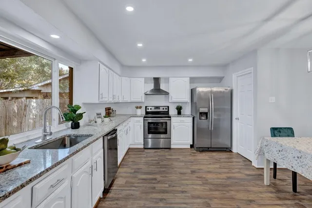 a kitchen with granite countertop a refrigerator and a sink