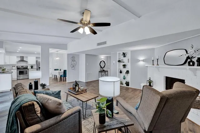 a living room with furniture a fireplace and kitchen view