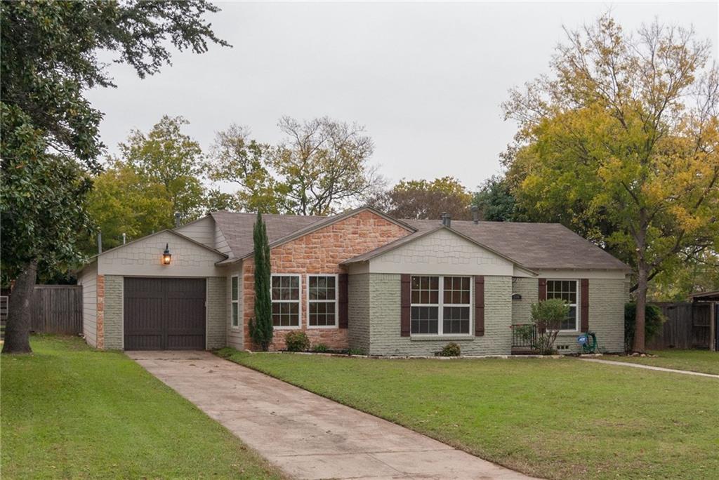 a front view of a house with a garden and yard