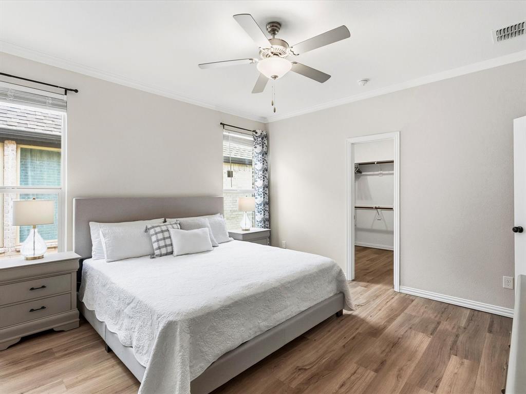 16936 Post Cedar Drive Justin, TX 76247 - Photo 12 of 30 Bright bedroom featuring wood-finish flooring, white walls, and a ceiling fan with integrated lighting
