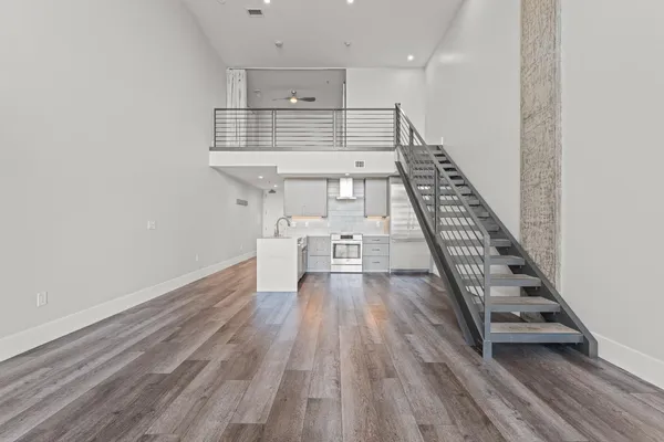 a view of a hallway with wooden floor and a bathroom