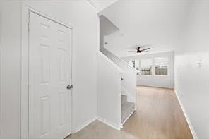 a view of a hallway with wooden floor and entryway