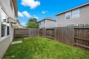 a view of backyard with wooden fence and large trees