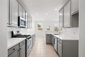 a kitchen with stainless steel appliances granite countertop a sink stove oven and cabinets