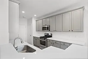 a kitchen with granite countertop white cabinets and stainless steel appliances