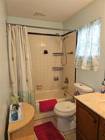 a bathroom with a granite countertop sink toilet and mirror