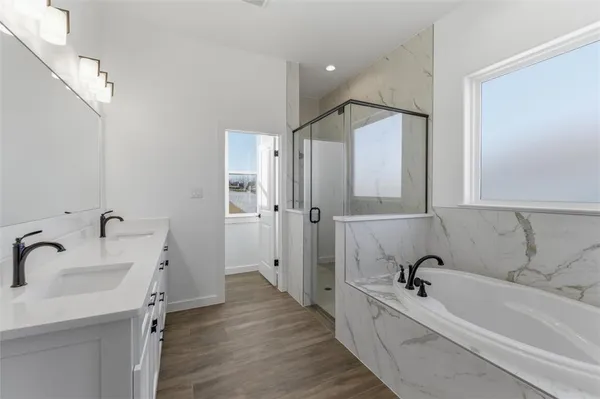 a bathroom with a tub a sink and mirror