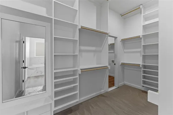 a view of walk in closet with empty racks