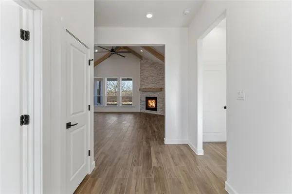 a view of a hallway with wooden floor and a living room