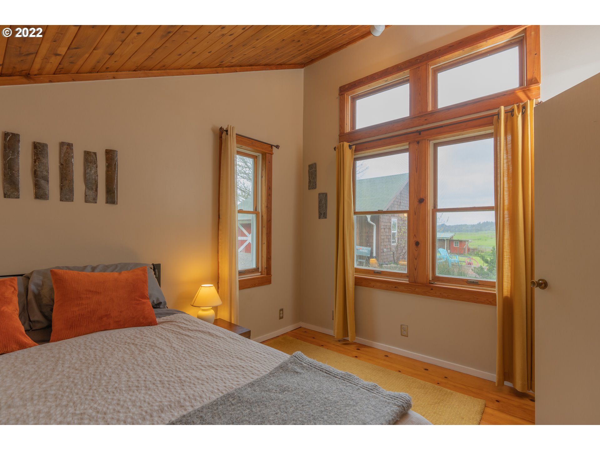 89907 Youngs River Road Astoria, OR 97103 - Photo 16 of 32 a bedroom with a bed and wooden floor