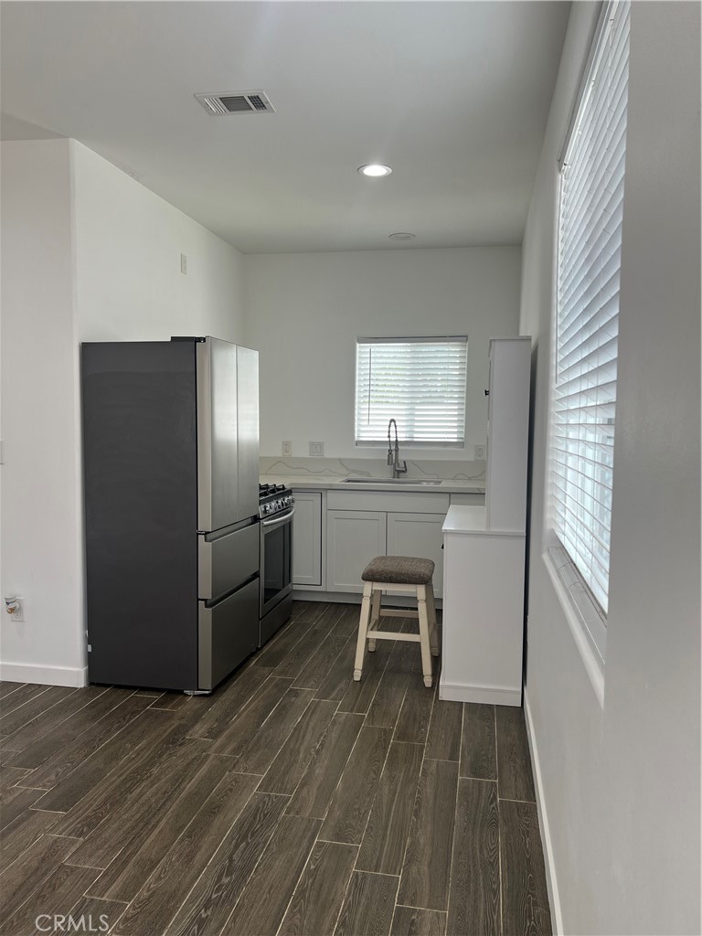 2357 Ellen Street Colton, CA 92324 - Photo 7 of 15 a kitchen with stainless steel appliances a refrigerator sink and wooden floor