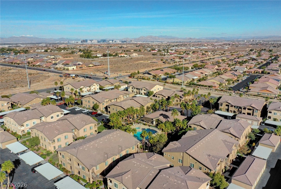8985 South Durango Drive, Unit 2187 Las Vegas, NV 89113 - Photo 49 of 73 An aerial perspective showcases a vibrant community with resort-style pool amenities and mountain backdrops.