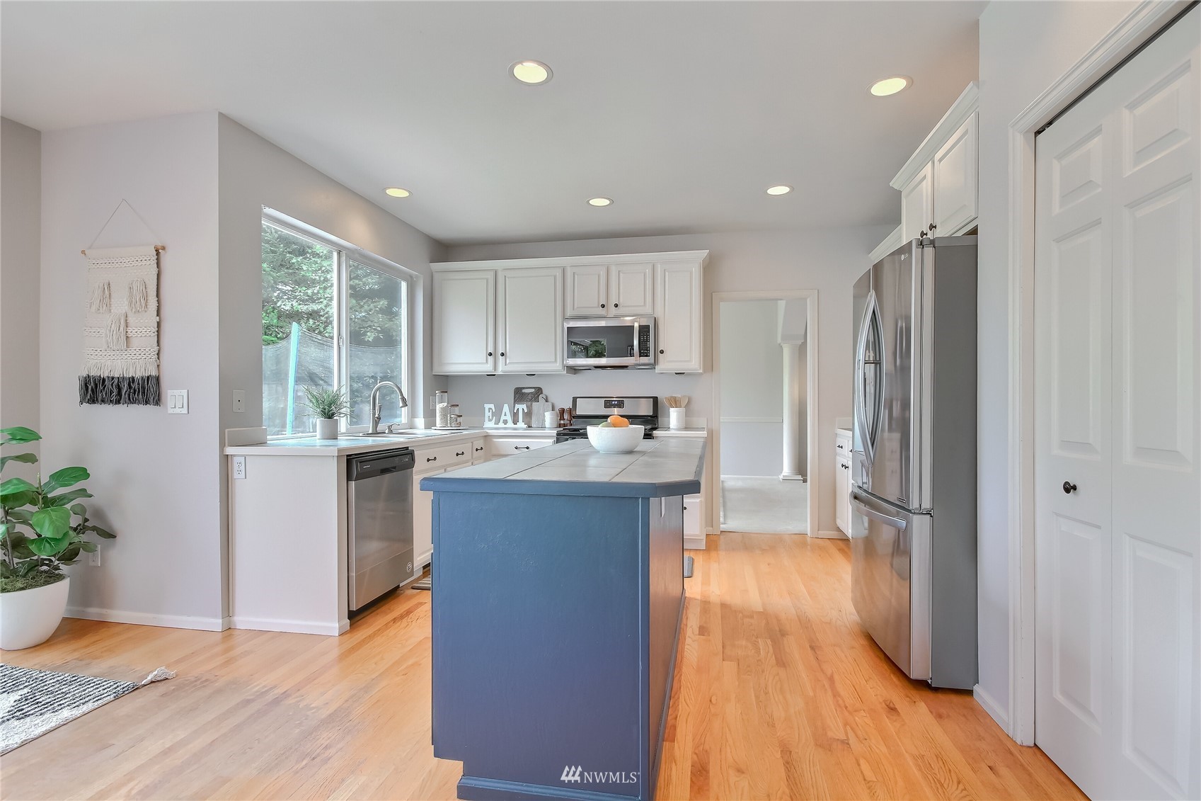 3007 204th Street Southeast Bothell, WA 98012 - Photo 9 of 37 a kitchen with stainless steel appliances granite countertop a refrigerator a sink dishwasher a stove and white countertops with wooden floor