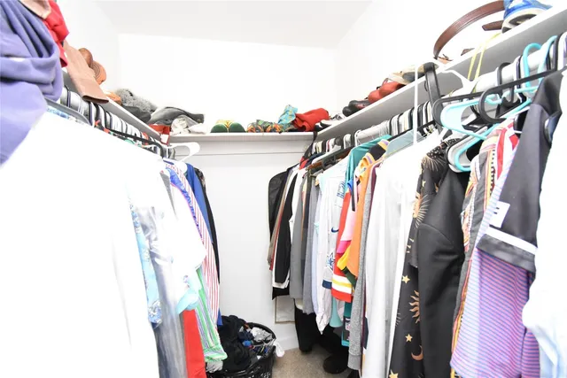 a view of walk in closet with clothes and shoes