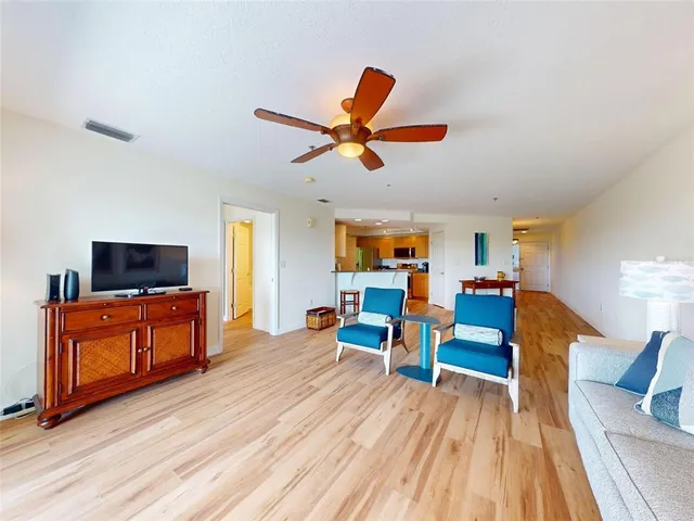 a living room with furniture a flat screen tv and kitchen view
