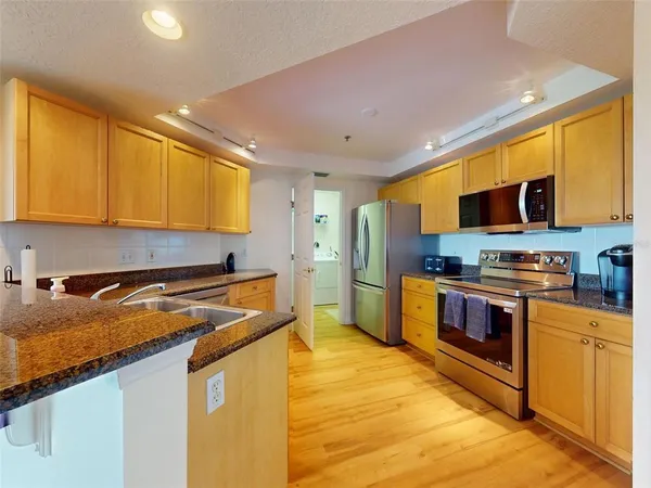 a kitchen with stainless steel appliances granite countertop a stove a sink and a refrigerator