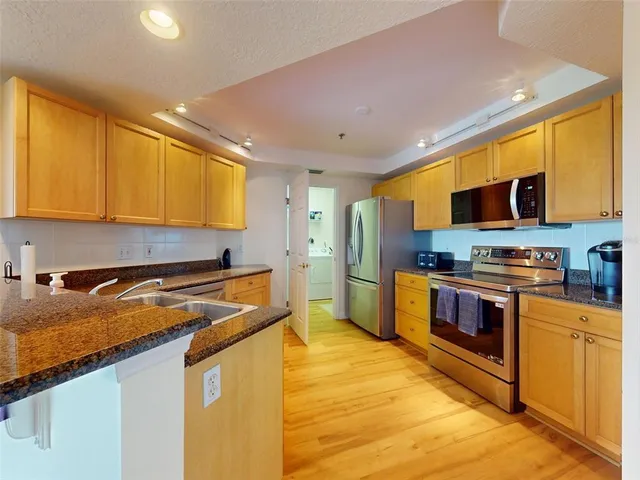 a kitchen with stainless steel appliances granite countertop a stove a sink and a refrigerator