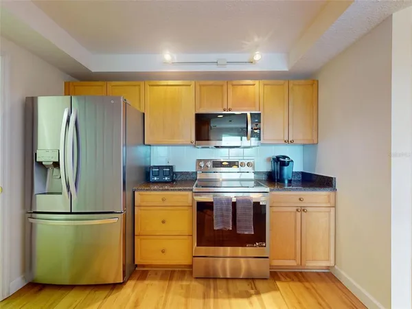 a kitchen with a refrigerator and a stove top oven