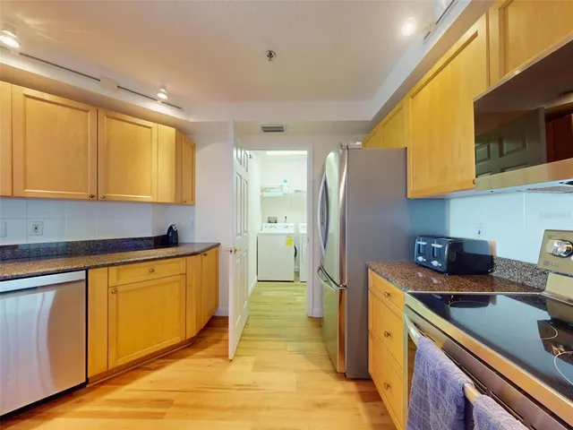 a kitchen with stainless steel appliances granite countertop a stove a sink and a microwave