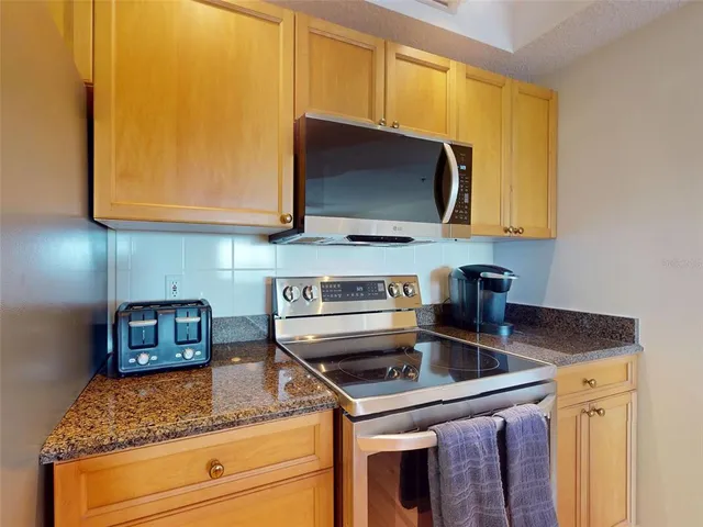 a kitchen with stainless steel appliances granite countertop a sink stove and microwave