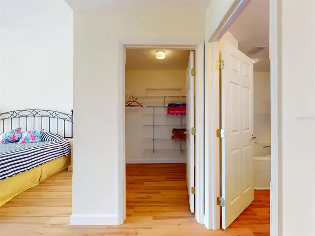 a view of a hallway with a door and wooden floor