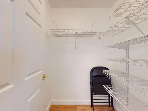 a view of pool with lawn chairs and large trees