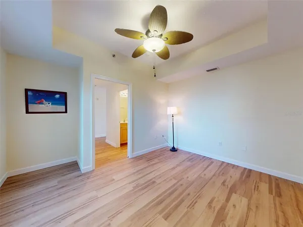 a view of an empty room with window and wooden floor