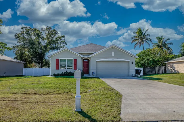 a front view of house with yard and garage