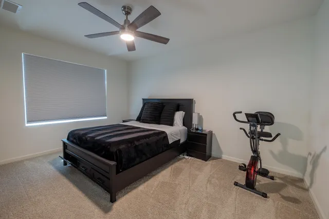a bedroom with a bed and a ceiling fan