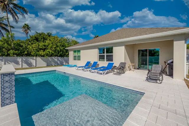 a backyard of a house with table and chairs