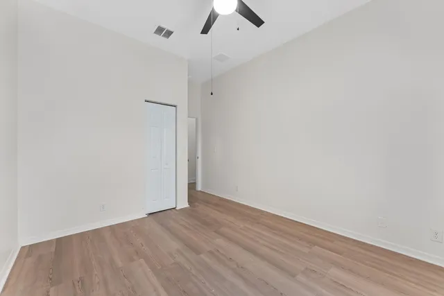an empty room with a ceiling fan and carpet