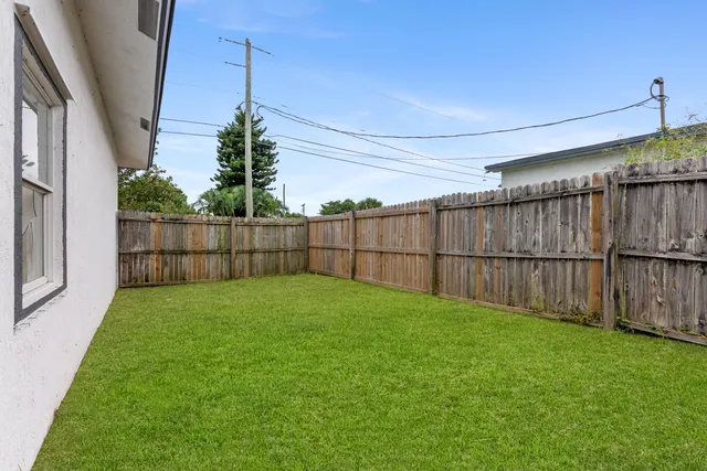 a view of backyard with wooden fence