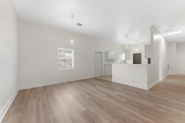 a view of a kitchen with wooden floor and white walls