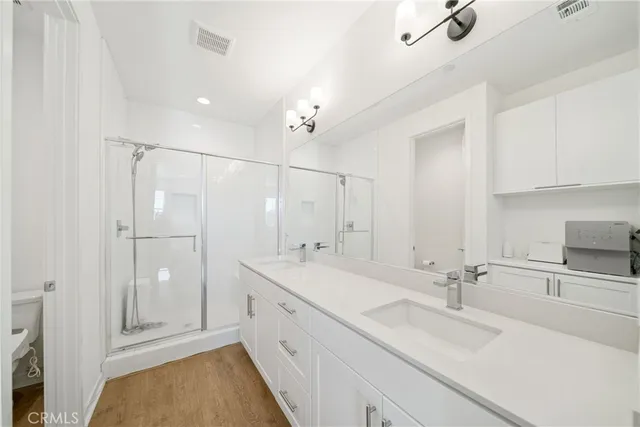 a bathroom with a sink vanity granite tub shower and a mirror