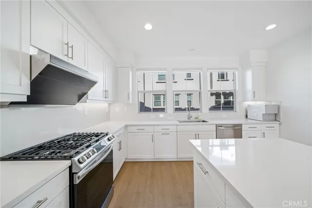 a kitchen with stainless steel appliances kitchen island granite countertop a sink and a stove