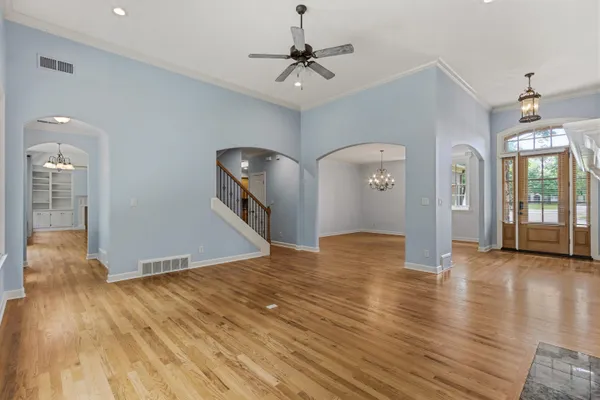 a view of a livingroom with wooden floor and a ceiling fan