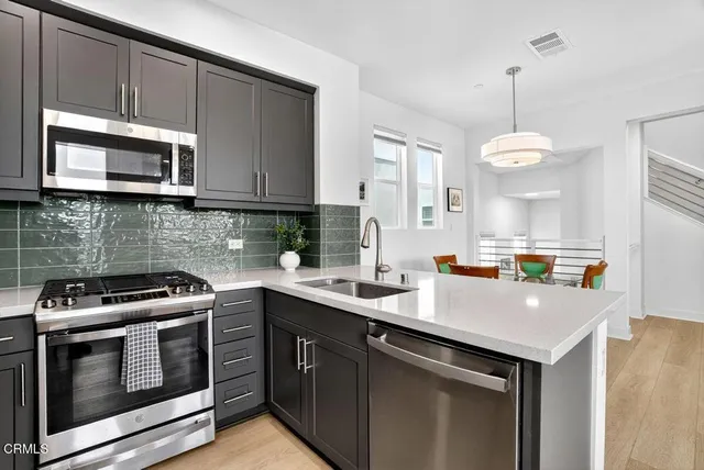 a kitchen with stainless steel appliances granite countertop a sink stove and microwave