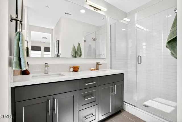 a bathroom with a sink vanity granite shower and a mirror